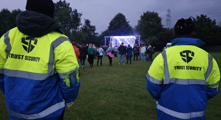 Two men stood watching his event in security clothing